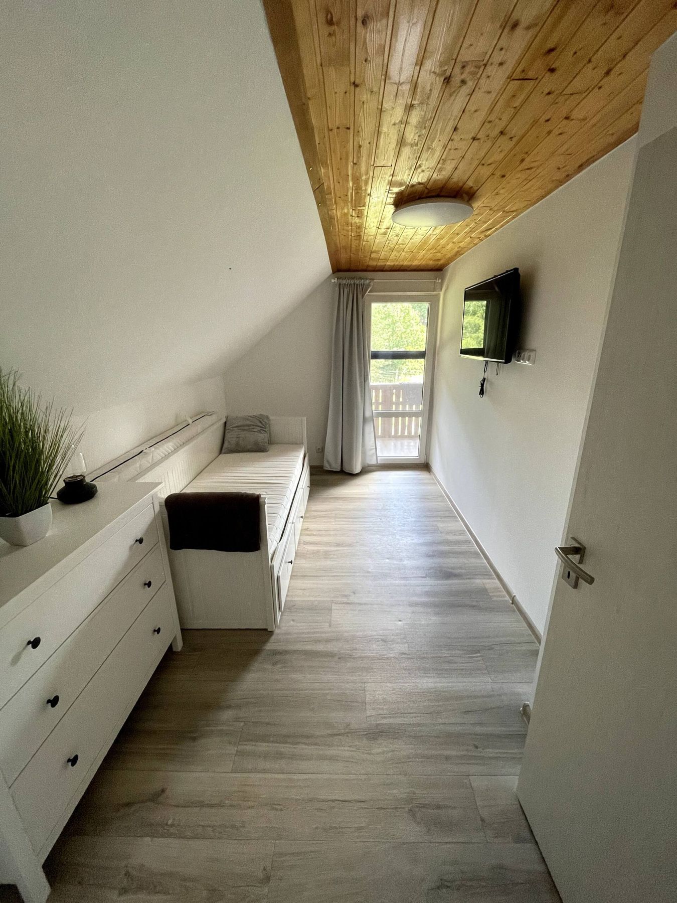 Ložnice s postelí a dveřmi na balkon
