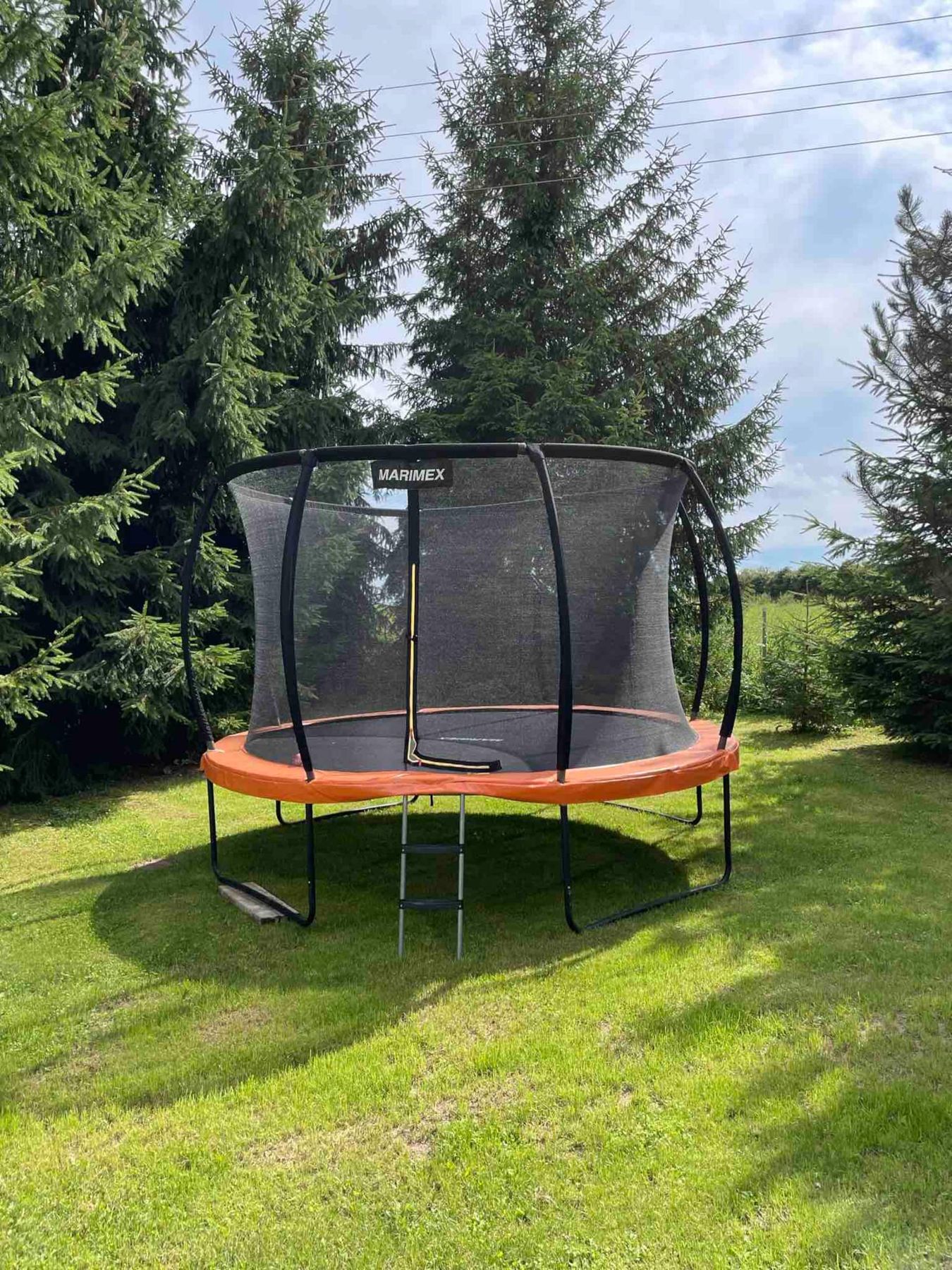Trampolína se sítí na trávníku